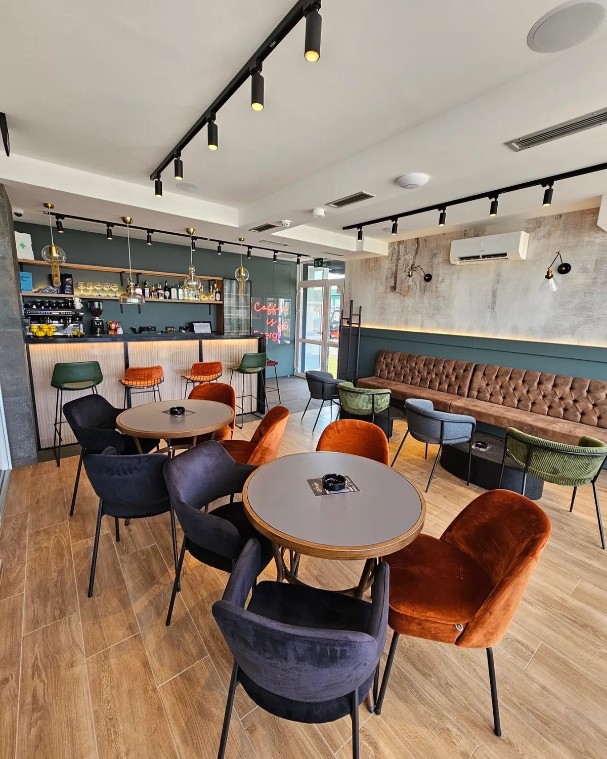 Interijer caffe bara s tapeciranim stolicama i barom